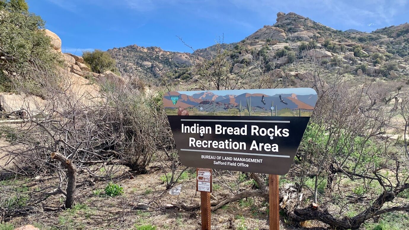 Sign for Indian Bread Rocks boondocking area amid desert boulders in Arizona