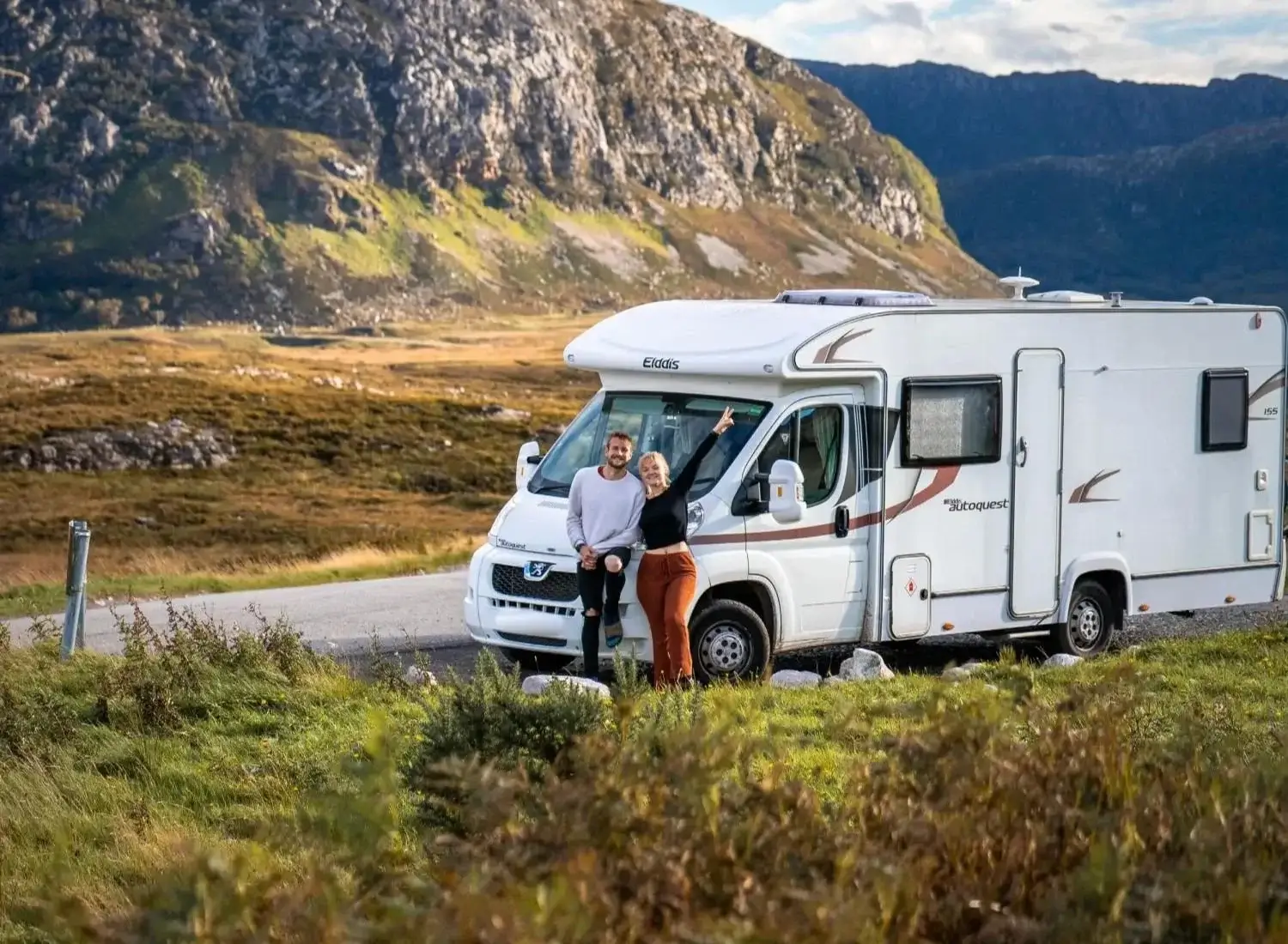 Two travellers beside a motorhome on the NC500 near Loch Eriboll in the Scottish Highlands